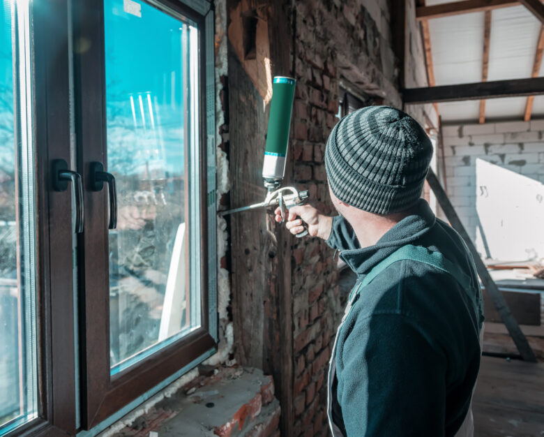 the builder fixes window with polyurethane foam